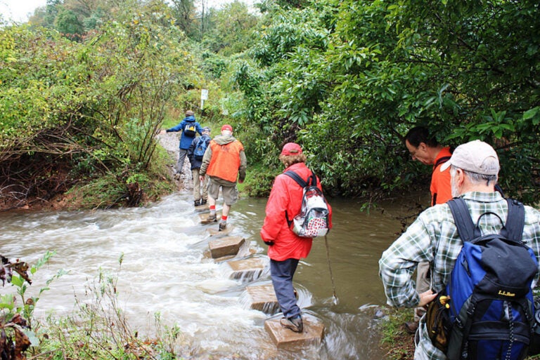 montco-annual-trail-challnege-EN-042225-02 Hikers crossing the Wissahickon creek