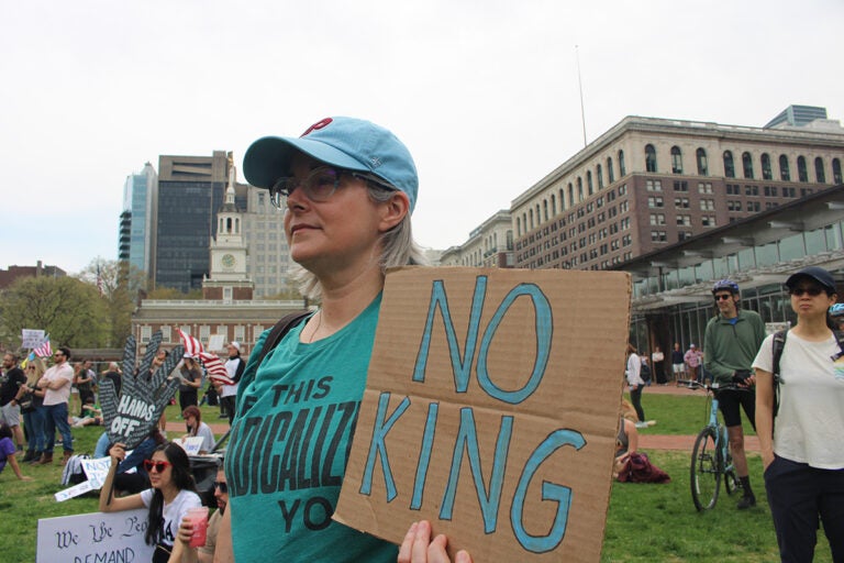 A woman holds a sign reading 