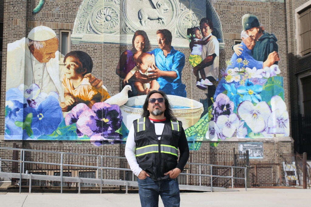 Mural designer Cesar Viveros in front of mural