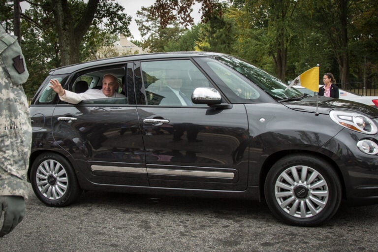 Pope Francis waves from a car