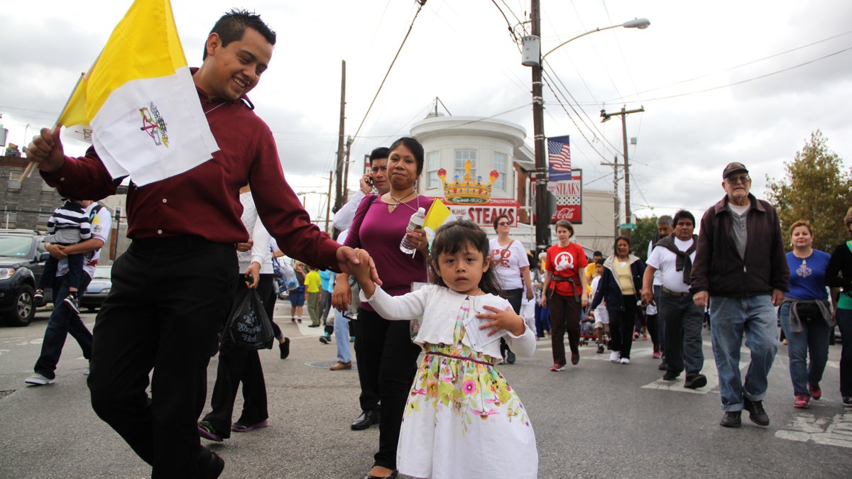 mexican Jose Fernandez and his daughter walk with a crowd near Geno's