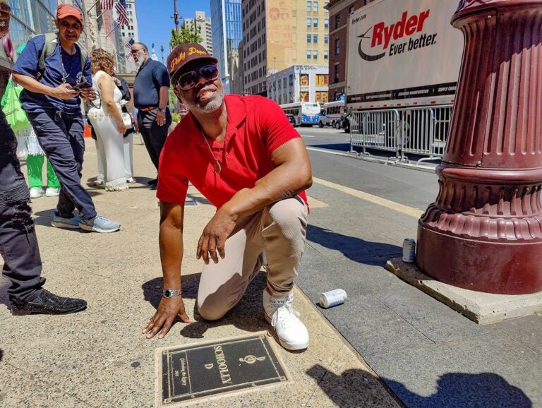Schoolly D posing for a photo with his plaque on the walk of fame