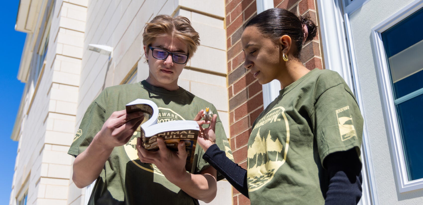 04 18 2025 k paynter odessa hs envirothon winners-5 Two students standing outdoors looking at a book together