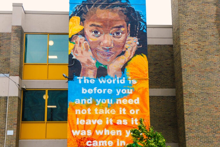part of the mural shows a young girls and reads The world is before you and you need not take it or leave it as it was when you came in
