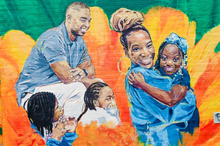 a mural shows two smiling adults and four smiling children
