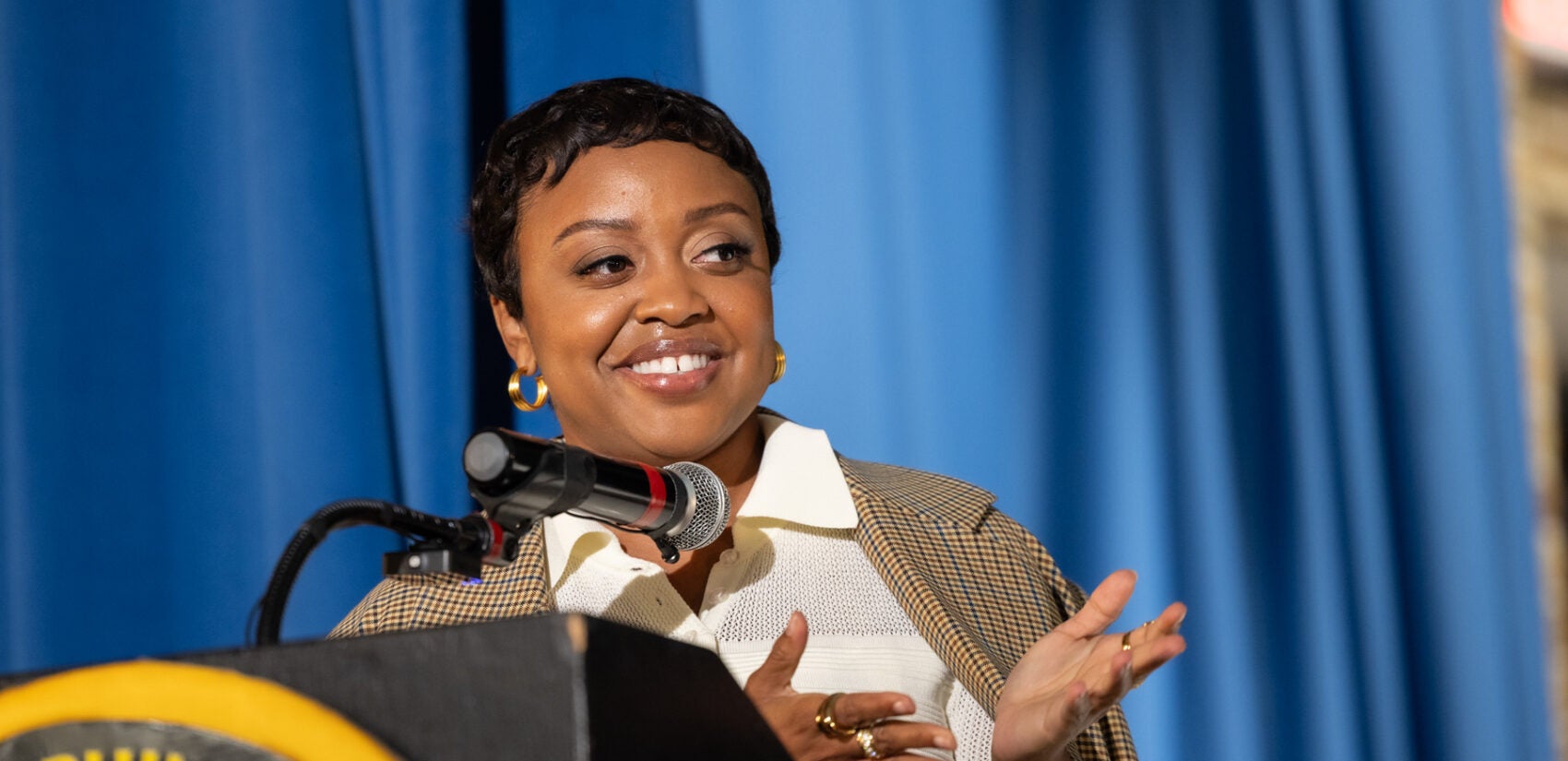 Quinta Brunson speaks behind a podium