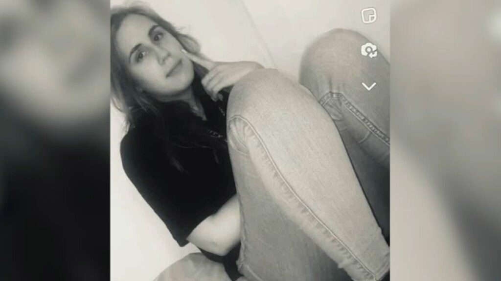 Taylor Daniel, a woman who was shot to death in March 2024, in a black and white photo sits wearing jeans