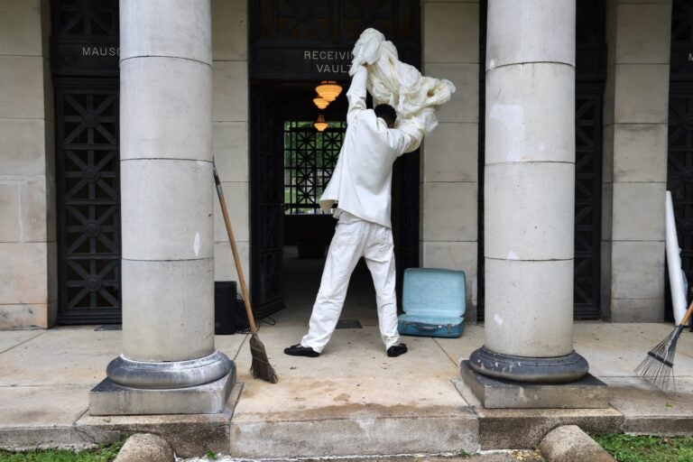 DonChristian Jones sweeps the entrance to Laurel Hill Cemetery's Receiving Vault for the Death and Arts Festival