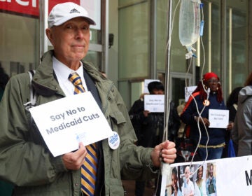 A man holds a sign that says 