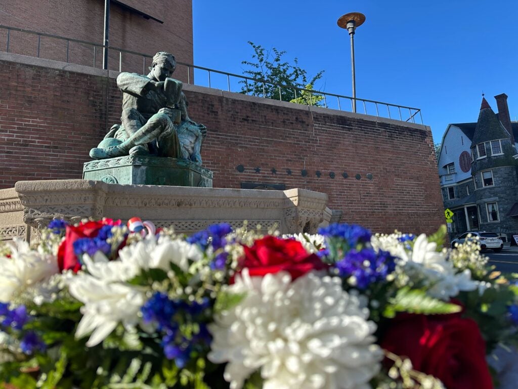 A wreath is laid before a war memorial statue