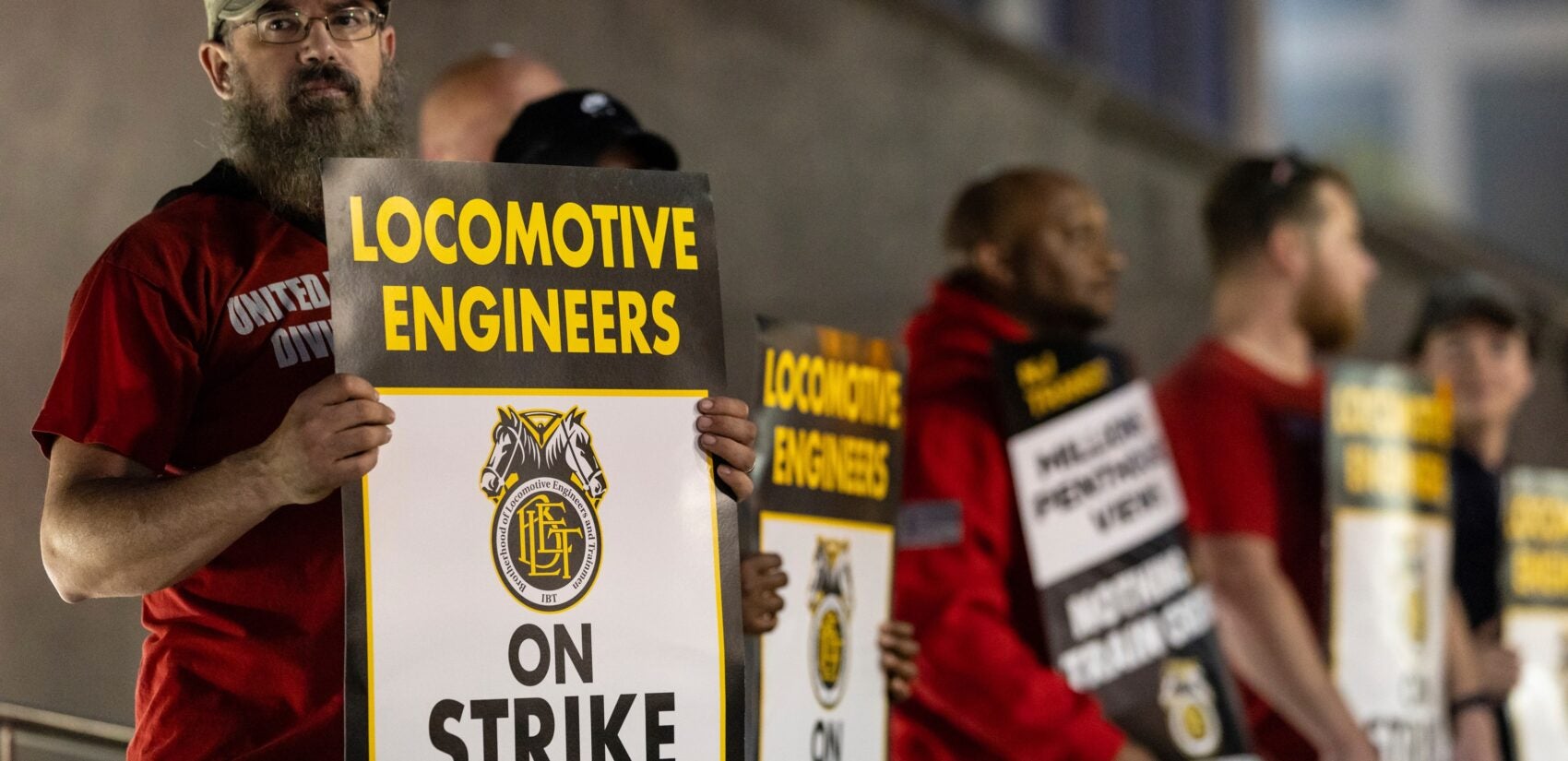 NJ-Transit-strike-2025-05-16-locomotive-engineers Union members from the Brotherhood of Locomotive Engineers and Trainmen form a picket line, with signs reading LOCOMOTIVE ENGINEERS ON STRIKE