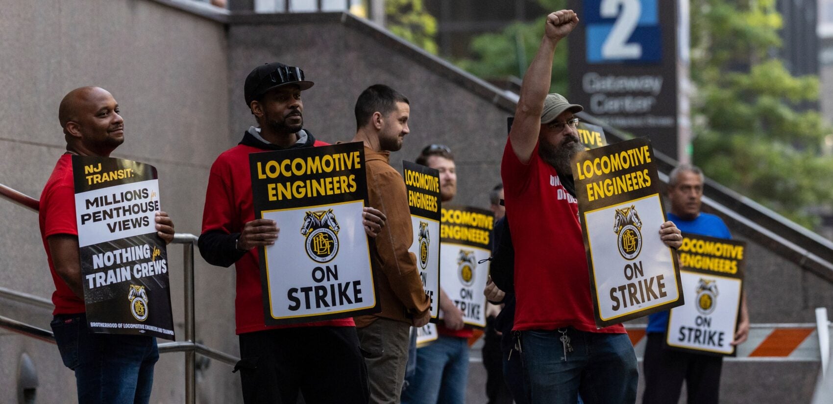 NJ-Transit-strike-2025-05-16-locomotive-engineers-2 around 7 union members from the Brotherhood of Locomotive Engineers and Trainmen form a picket line, with signs reading LOCOMOTIVE ENGINEERS ON STRIKE