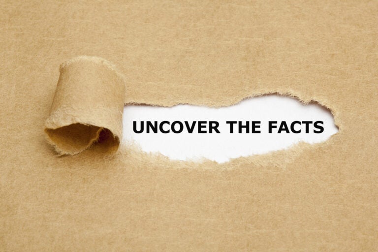 Uncover The Facts Uncover The Facts appearing behind torn brown paper.
** Note: Shallow depth of field