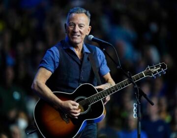 Bruce Springsteen performing on stage with a guitar