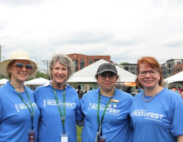 From left, Krisy Elisii, Glenda Childs, Kate Steck and Lauren Ford, organizers of the seventh annual Bucks County Book Festival, pose for a photo on Saturday, May 3, 2025, at Broad Commons Park in Doylestown. (Emily Neil/WHYY)
