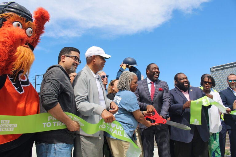 Elected officials, stakeholders and Gritty cut the ribbon to officially open the Christian to Crescent section of the Schuylkill River Trail. (Emily Neil/WHYY)