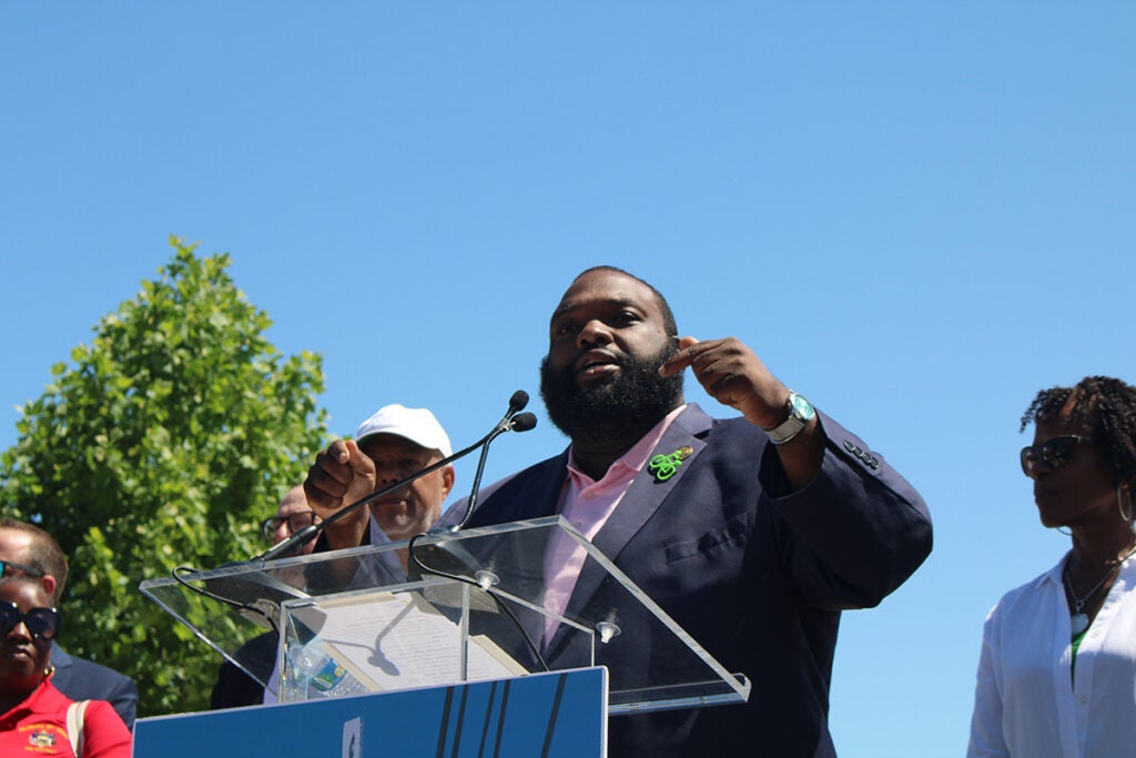 State Rep. Jordan Harris stands at a podium at the opening of the Schuylkill River Trail in Philadelphia