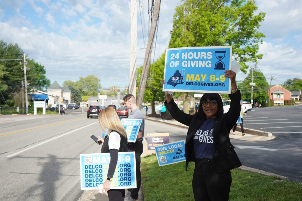Delco Gives Day volunteers hold signs for the event