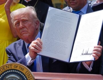 Donald Trump holds up a signed executive order