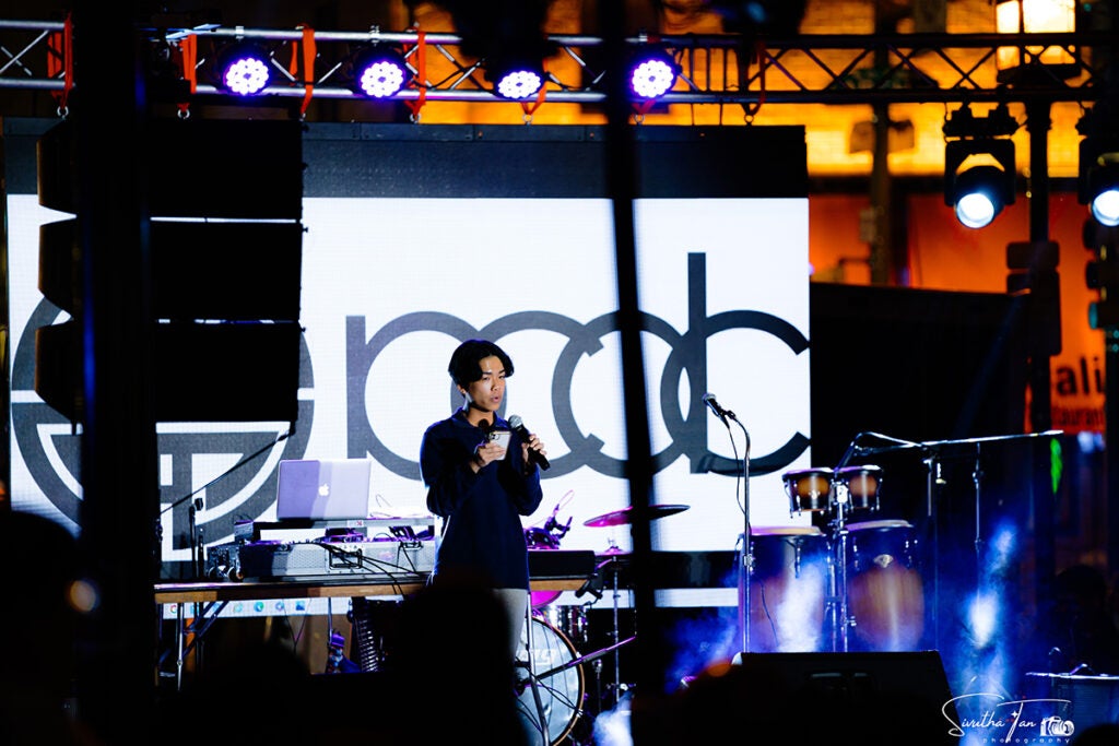 Evan Wang speaks into a microphone onstage