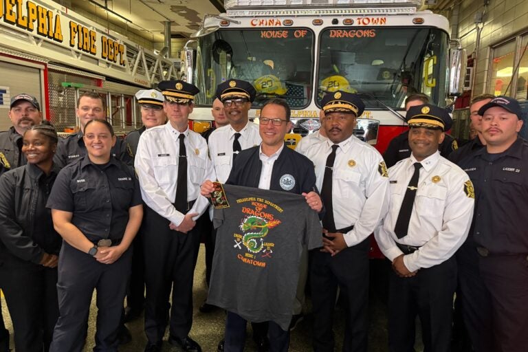 Josh Shapiro displays a shirt he received from firefighters at Engine 20 in Chinatown