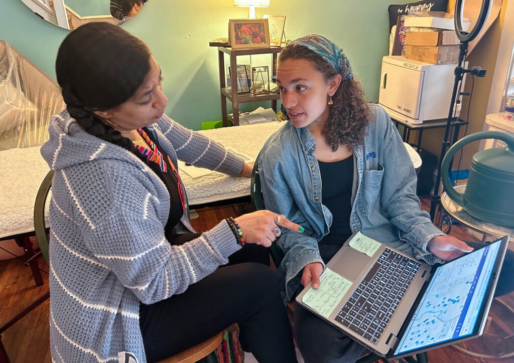 Tina Alishia Brown and Jendaiya Hill looking at a laptop computer together