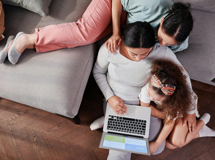 Mother and Daughters Sitting with Laptop
