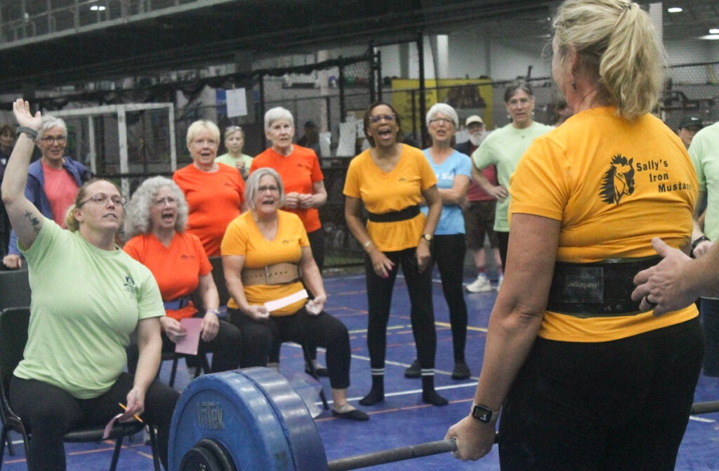 Sally’s Iron Mustangs cheer on teammate Kathy Kirk