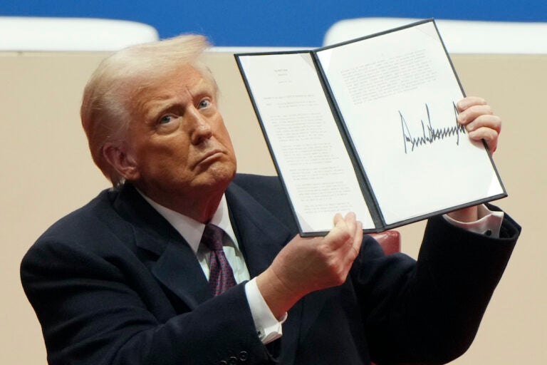 Trump Transgender Health Policy President Donald Trump holding up executive order