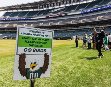 A sign on the field tells people to stay off the grass