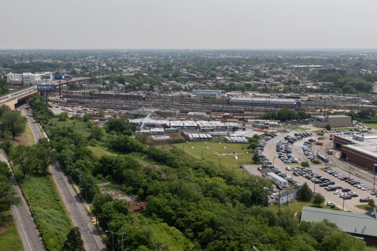 an aerial view of water being sprayed over the burned SEPTA buses