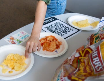 People reaching for chips on a plate