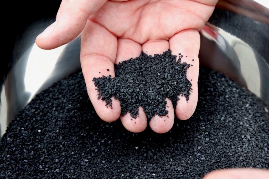 A hand shows the granulated activated carbon that will be used to remove PFAS from the water supply at Veolia's Stanton treatment plant