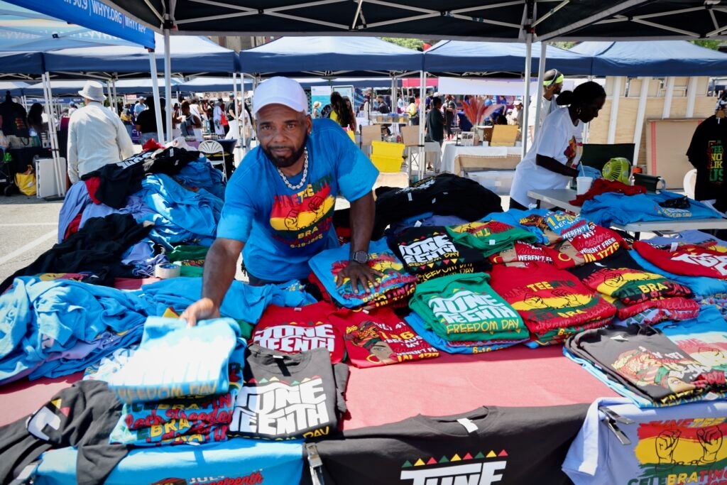 A man at his booth selling shirts