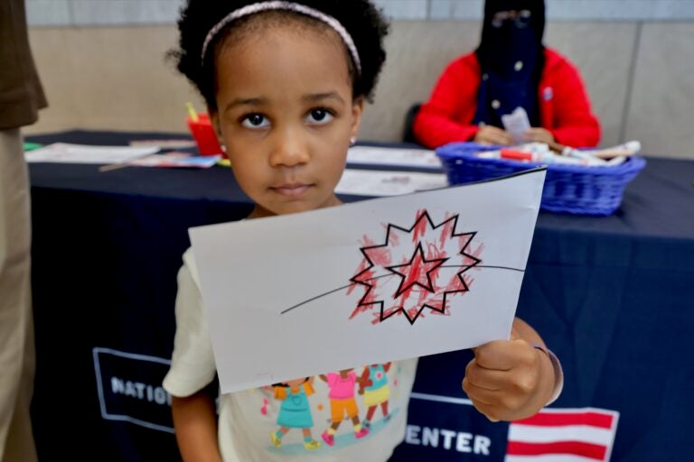 2025 06 19-e lee-zoe joyce umble-philadelphia national constitution center-juneteenth flag A young girl holds up a flag she made