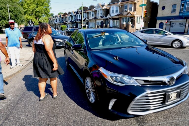 Yasmeen Williams speaks to a driver at the intersection of Baltimore Avenue, Cobbs Creek Parkway and 58th Street