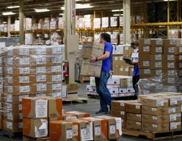 Workers carry boxes in a warehouse