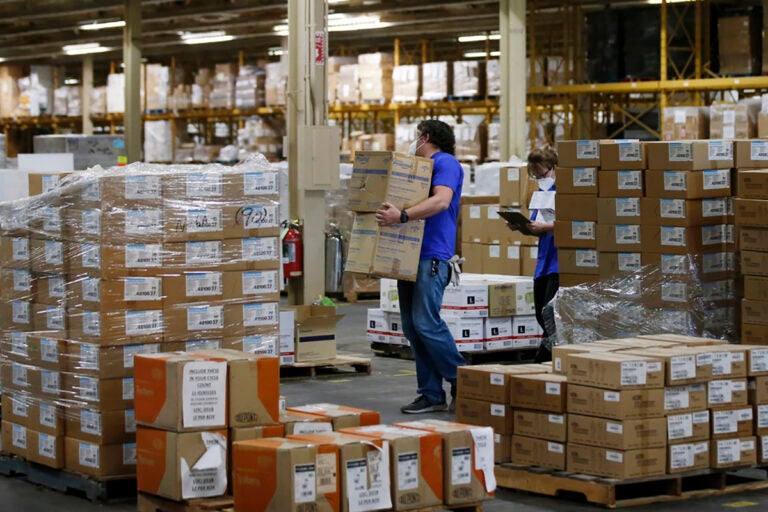 National Stockpile Workers carry boxes in a warehouse