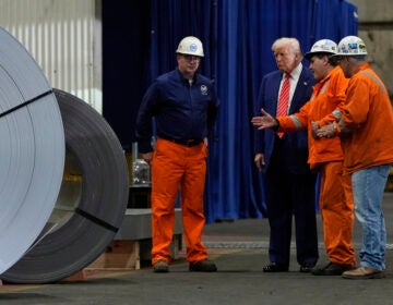 President Donald Trump talks to steel workers