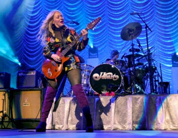 The band Heart performs live on stage, with Nancy Heart playing an electric guitar