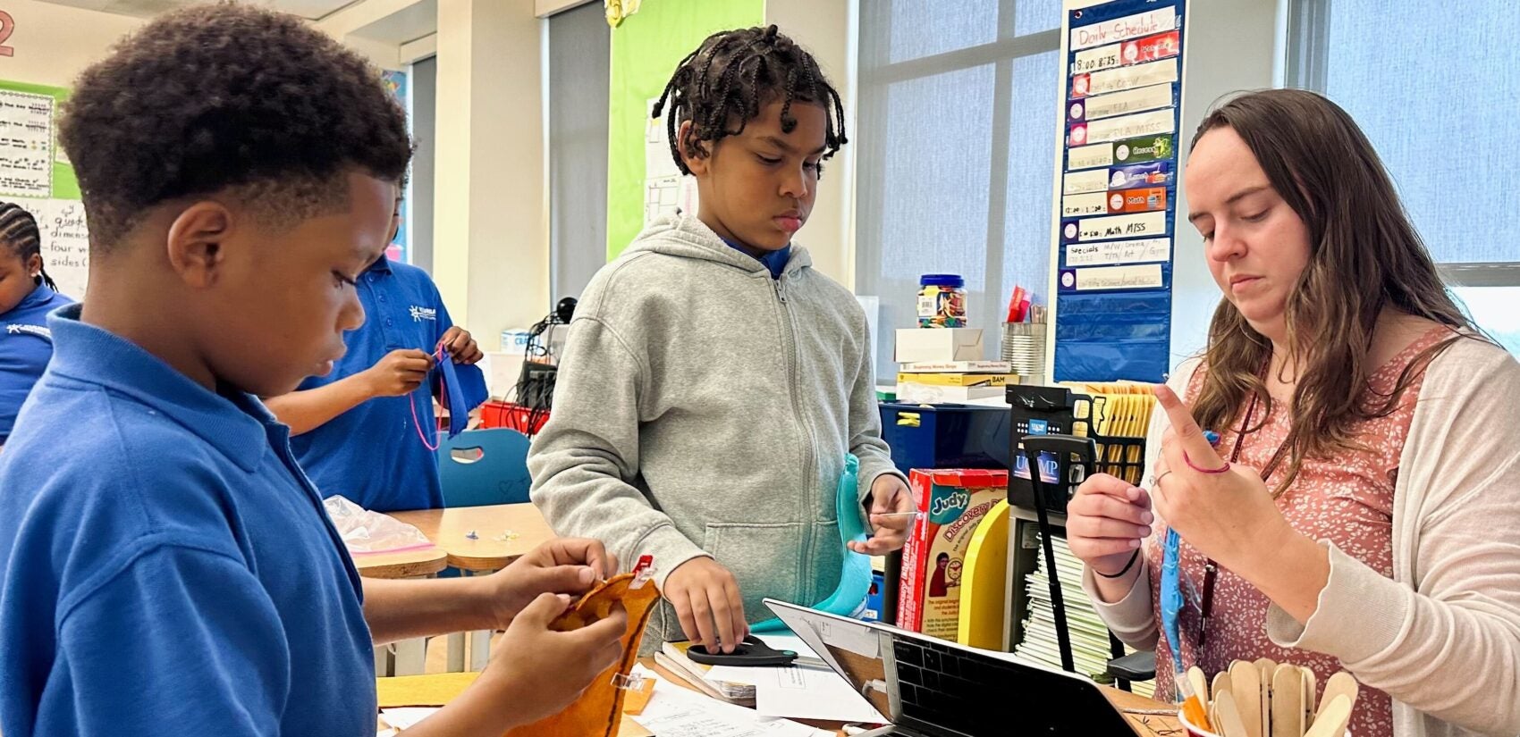 Kuumba-Academy-Delaware-arts-puppets-2025-8-newest Emma Salisbury helps two students with a puppet