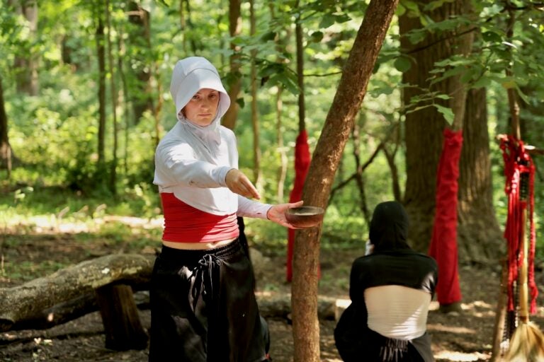 A dancer spreads dust during a performance at the Schuylkill Center