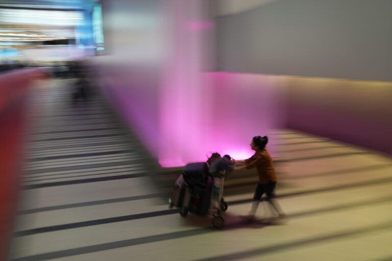 airport-traveler-file-ap A traveler pushes a luggage cart through the international arrivals area at the international airport in Los Angeles