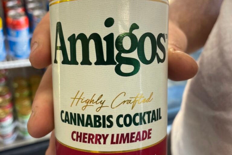 a close-up photo of someone holding an 'Amigos' can