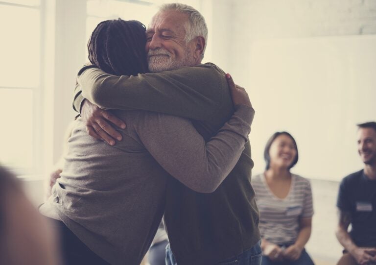 Old guy consoling a woman with a hug Old guy consoling a woman with a hug