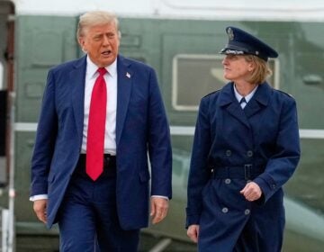 Donald Trump, escorted by Angela F. Ochoa, walks from Marine One to board Air Force One