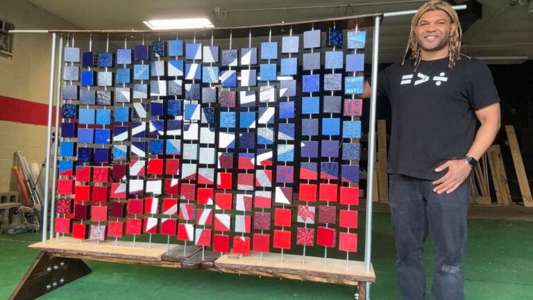 juneteenth-flag-artist-EN-061325-02 Kevin Aster Young posing with artwork