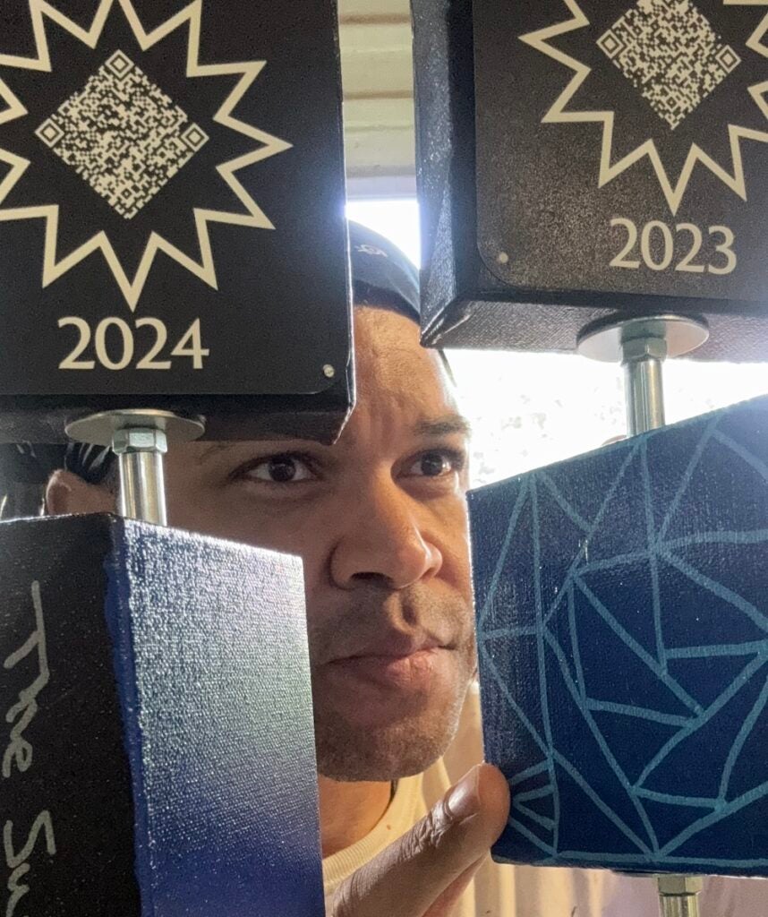 Kevin Aster Young posing with artwork