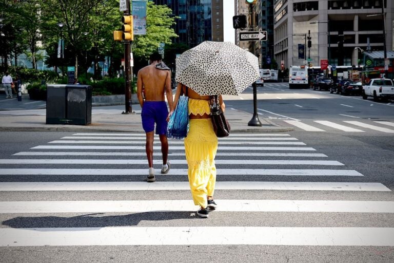 philadelphia-centercity-heatwave-EL-062325-02 A woman uses an umbrella for shade in Philadelphia