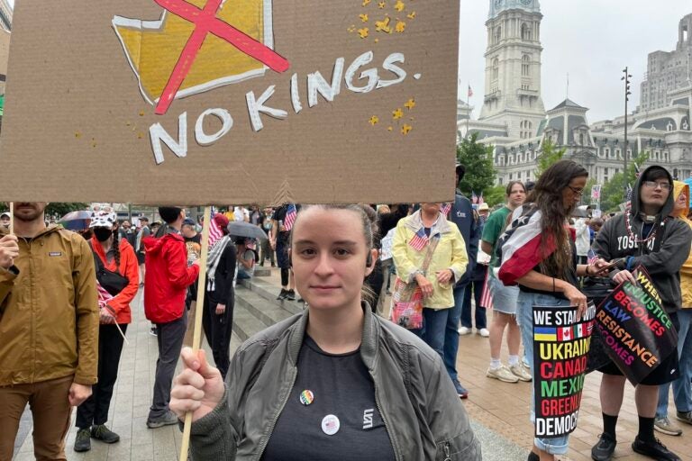 Casey Holden came by herself from Louisiana to attend the Philadelphia No Kings protest. She said she is protesting the Trump administration because she fears the country is in the “beginning stages” of authoritarianism. (Emily Neil/WHYY)